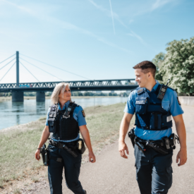 Polizeibeamtin und Polizeibeamter am Rhein. 