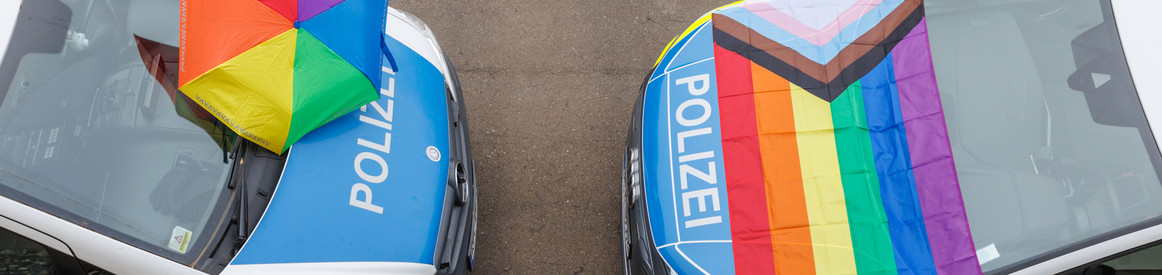2 Polizeiautos mit Pride Flagge