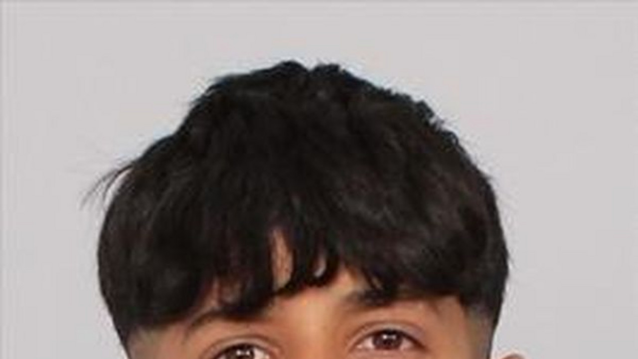 Porträt eines Jugendlichen mit türkisfarbenem Hemd vor hellem Hintergrund.