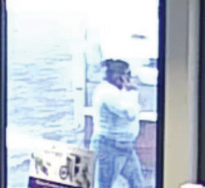 Bild aus der Überwachungskamera. Es zeigt eine Frau mit weißem Pullover, einer blauen Hose. Sie hat schwarze Haare.
