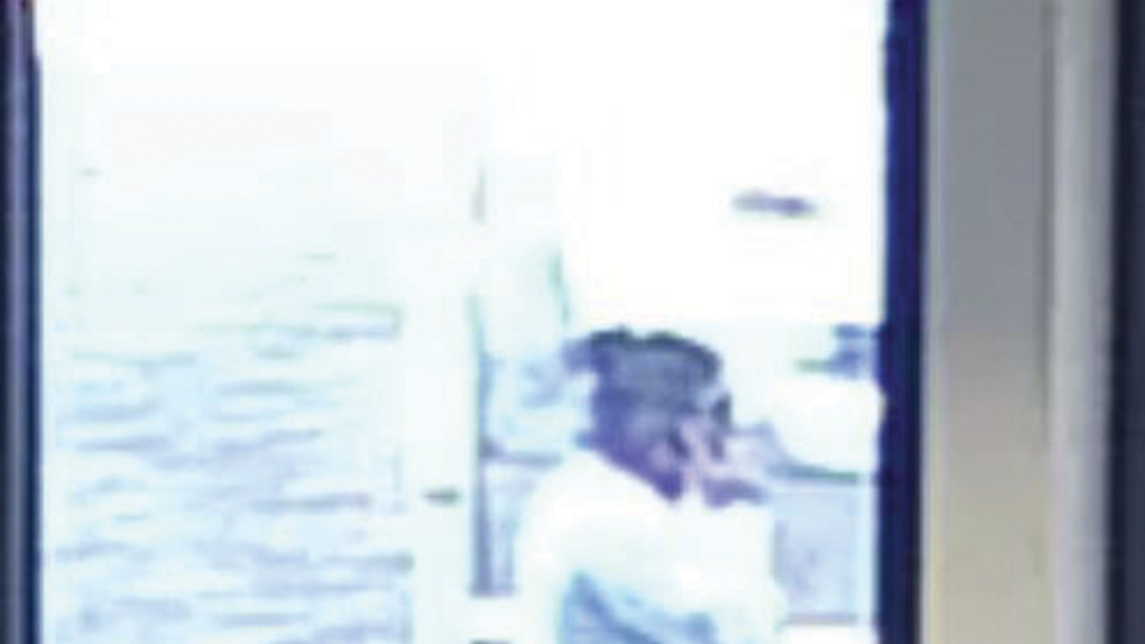 Bild aus der Überwachungskamera. Es zeigt eine Frau mit weißem Pullover, einer blauen Hose. Sie hat schwarze Haare.