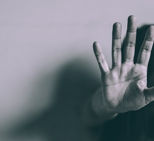 Frau, die nach unten schaut und eine abweisende Handbewegung macht