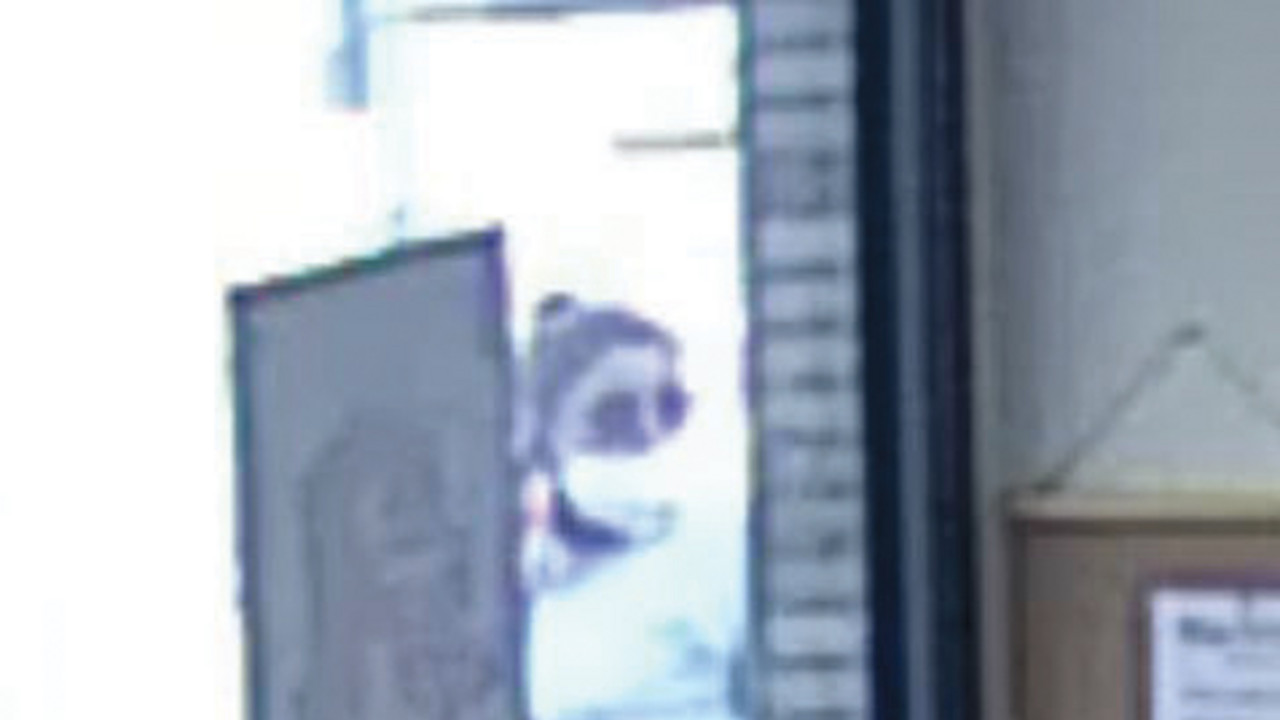 Bild aus der Überwachungskamera. Es zeigt eine Frau mit weißem Pullover. Sie hat schwarze Haare.