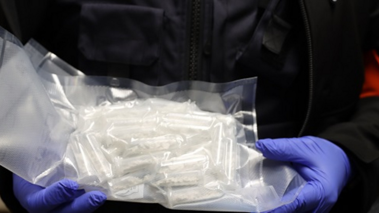Ein Zollbeamter hält eine Packung Kokain in der Hand