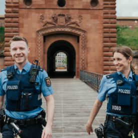 Polizeibeamter und Polizeibeamtin vor Tor in Germersheim.