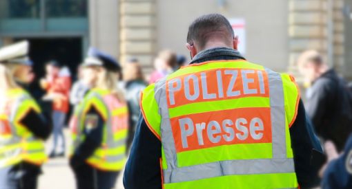 Polizist von hinten mit Rückenaufschrift Presse