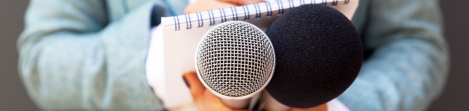 Mikrophone in den Händen einer Journalistin