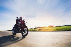 Ein Motorradfahrer fährt über eine Landstraße