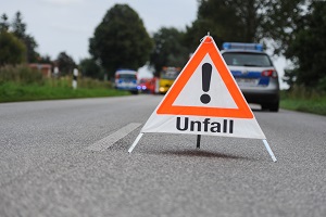 Die Polizei weist mit einem Warndreieck auf einen Unfallort in